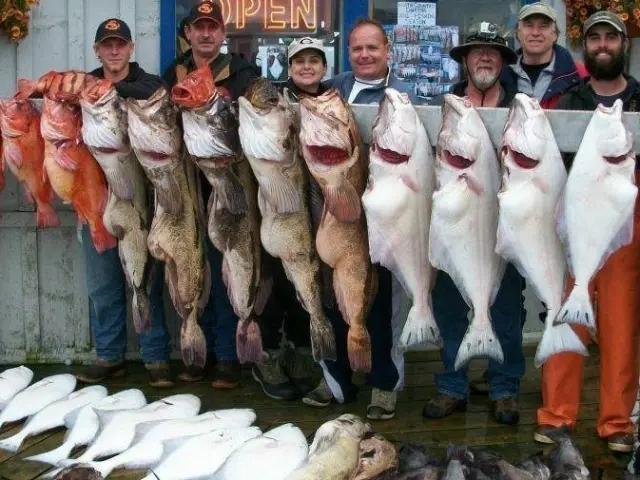 a group of people posing for a fish
