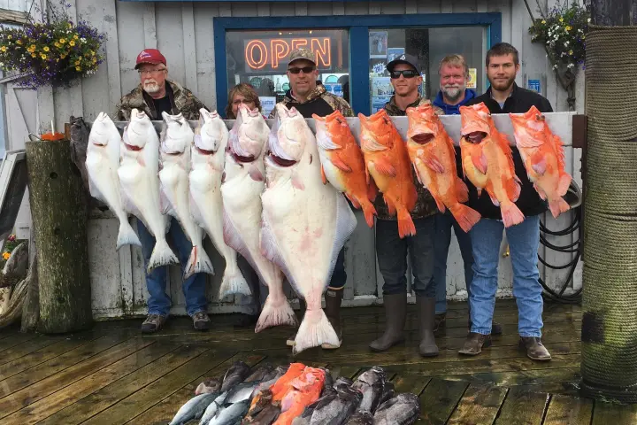 a group of people posing for a fish