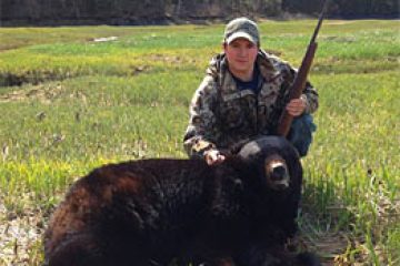 a man sitting on top of a grass covered field