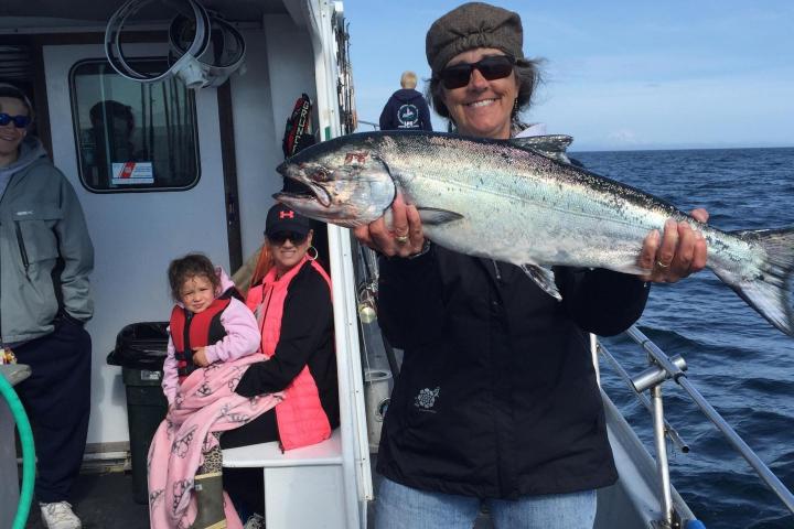 a man holding a fish on a boat
