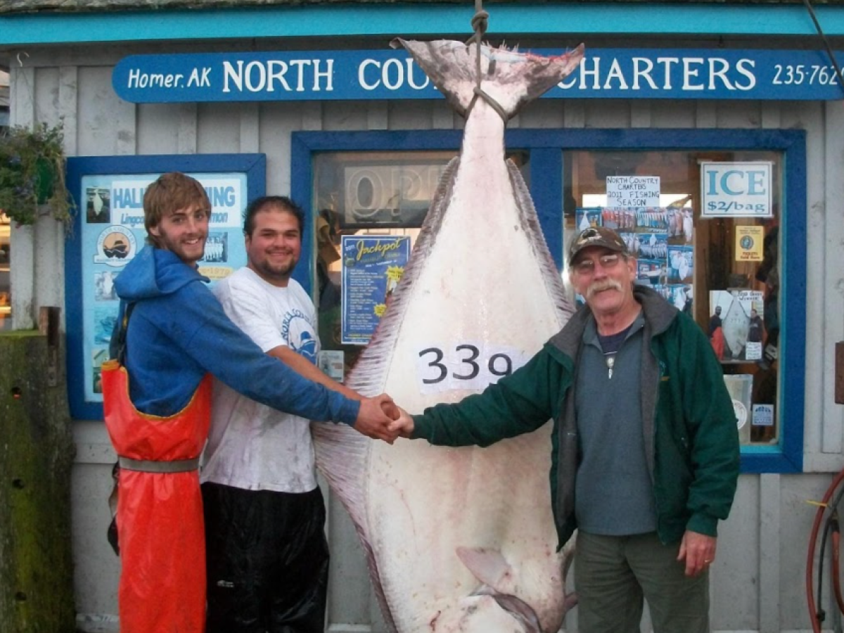 a group of people standing in front of a fish