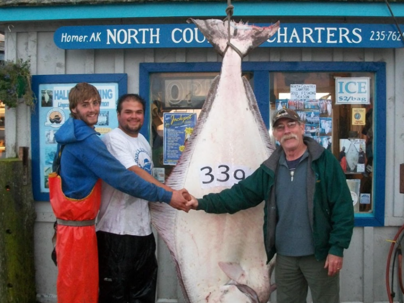 a group of people standing in front of a fish