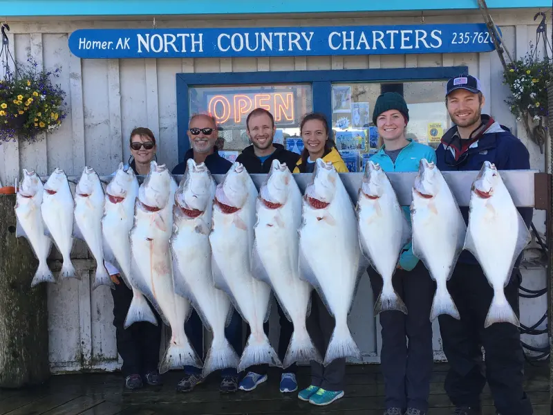 a group of people posing for a photo in front of a fish