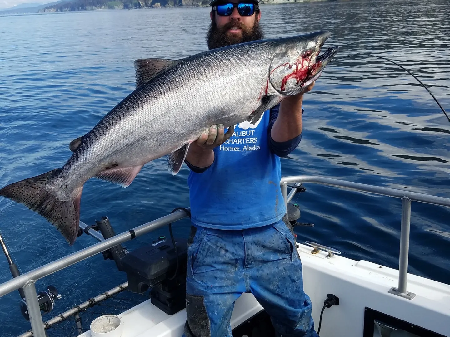 a person holding a fish on a boat in a body of water