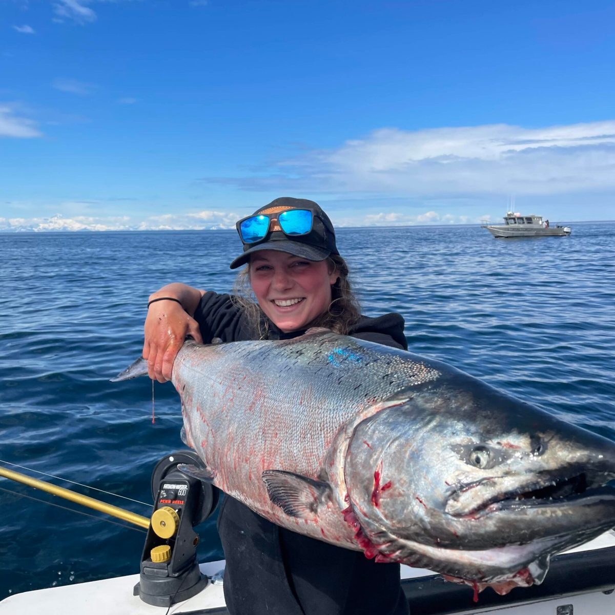 a person holding a fish on a boat in a body of water