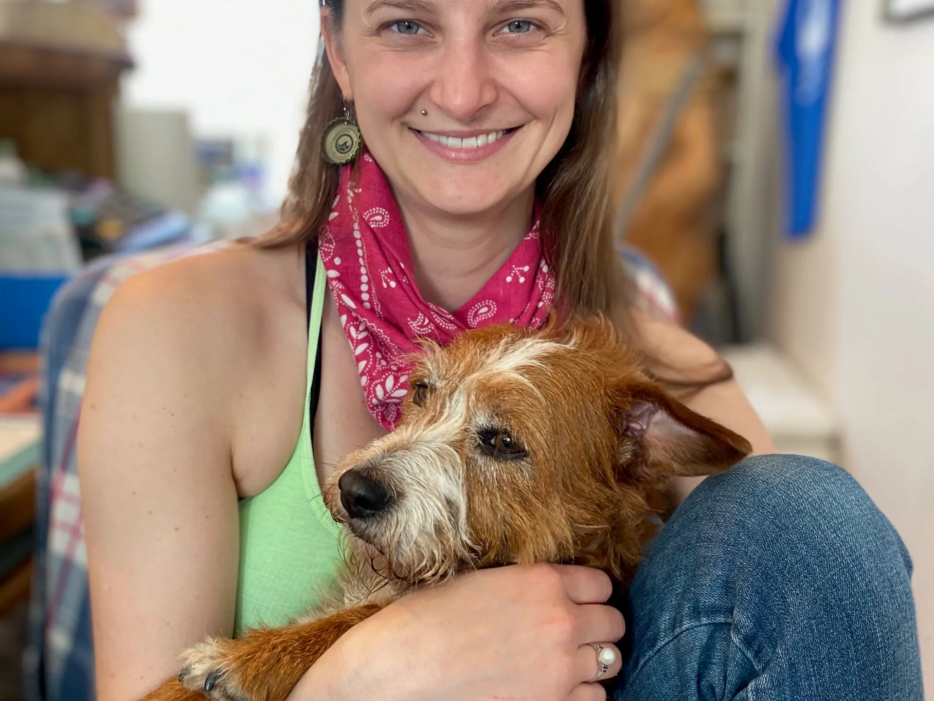 a woman holding a dog posing for the camera