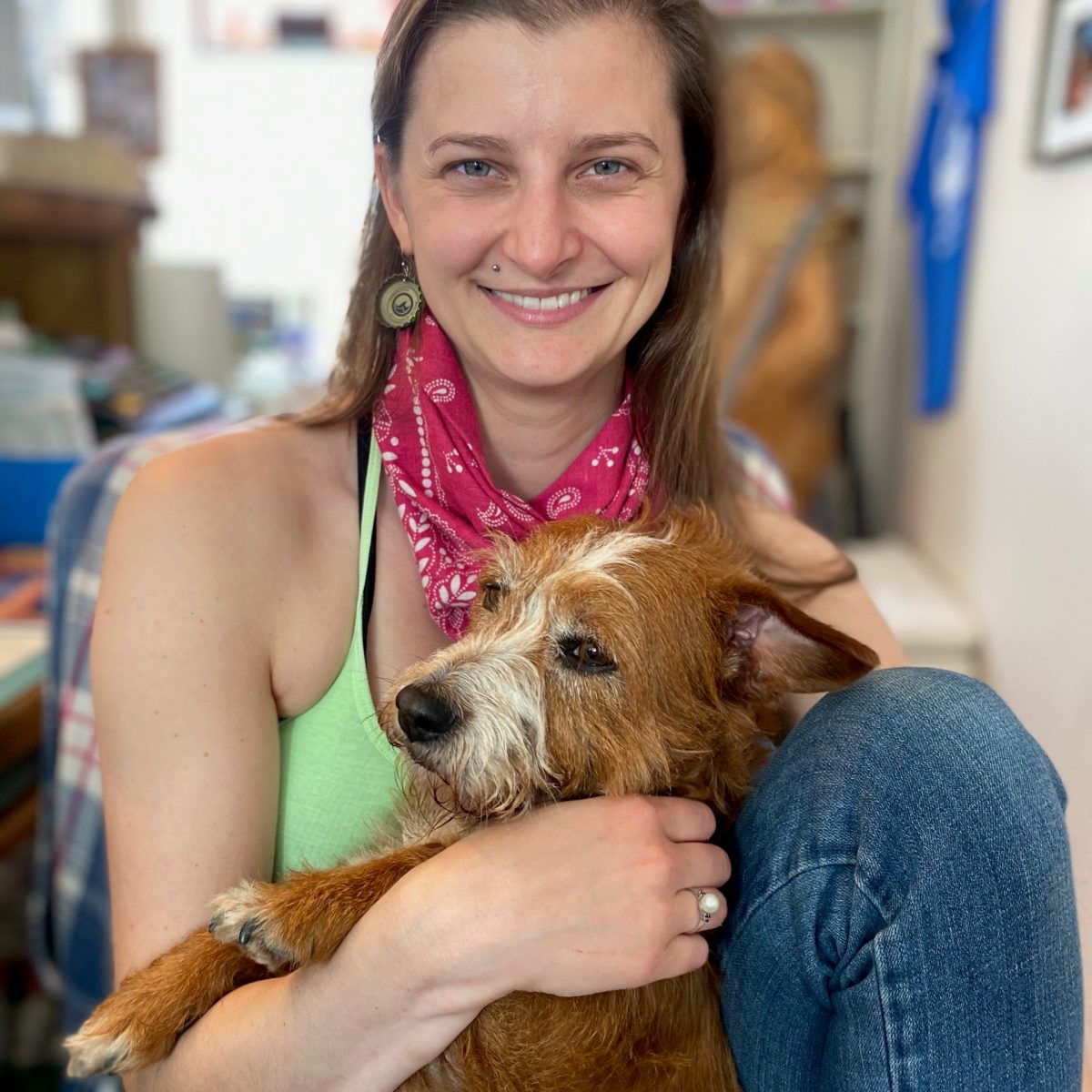 a woman holding a dog posing for the camera