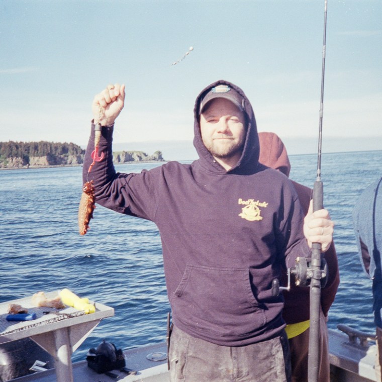a person standing next to a body of water posing for the camera